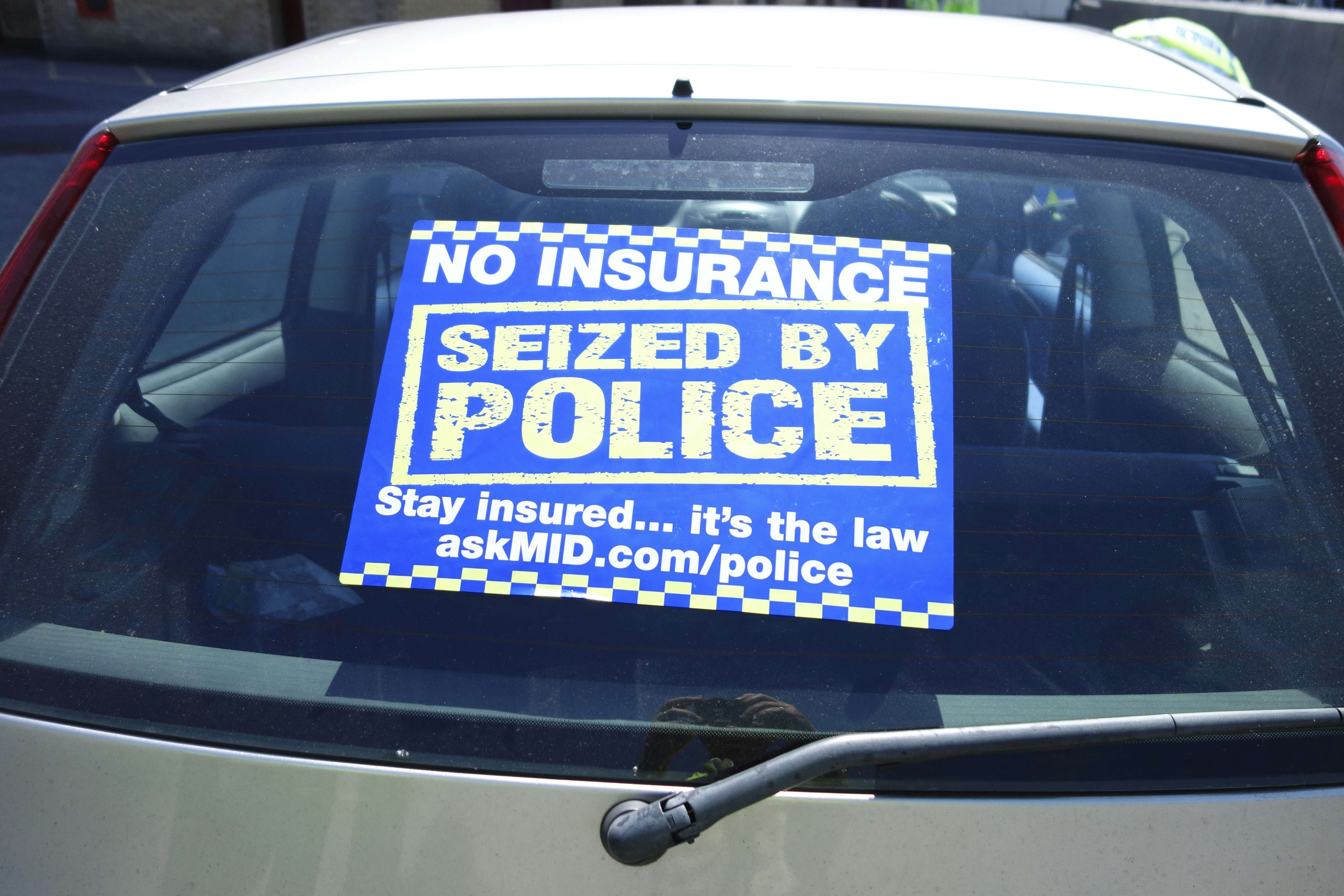 Police no-insurance seizure notice on a car's back window. 