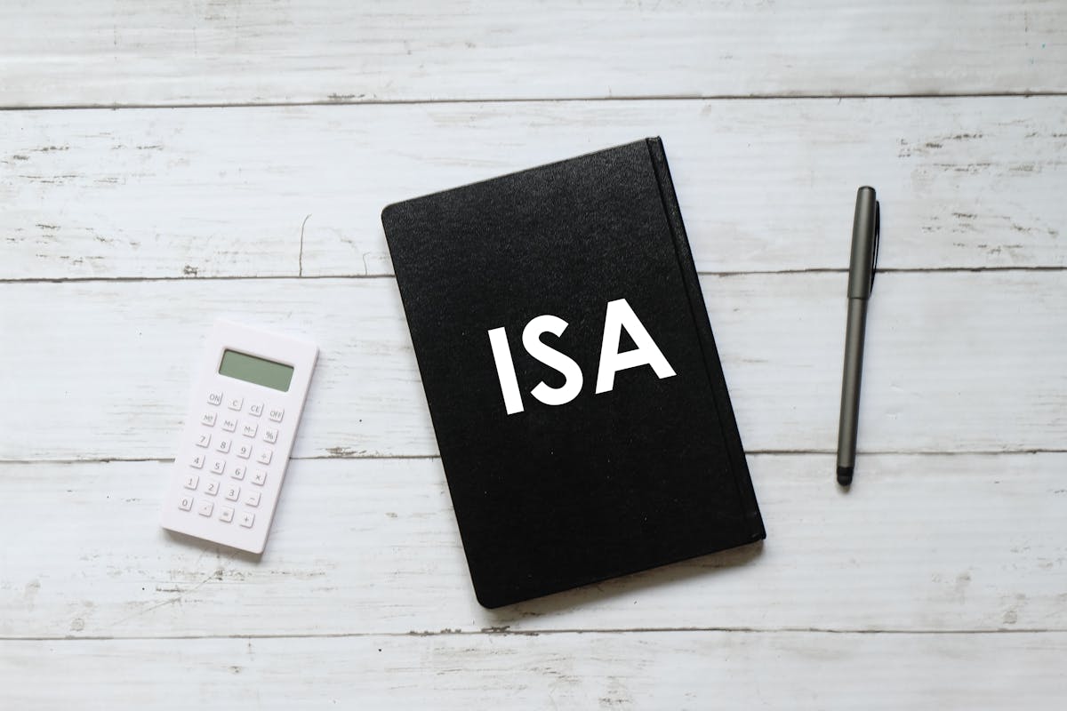 笔和笔记本写与ISA(个人储蓄帐户)在白色木制背景。