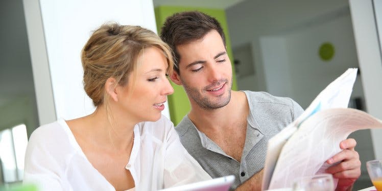 couple-at-home-looking-at-letters-news-and-tablet