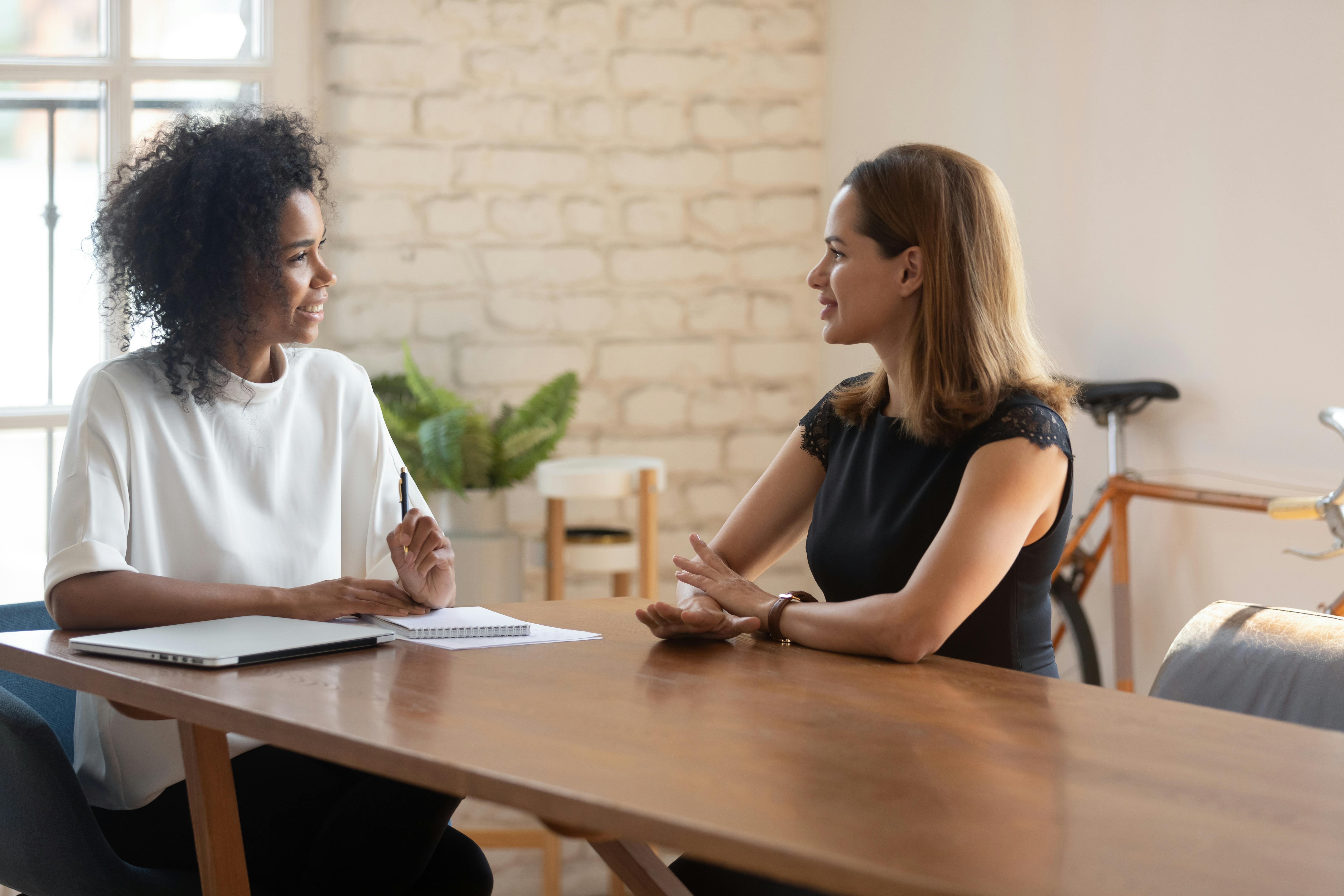 A woman interviewing another woman for a job in an informal setting