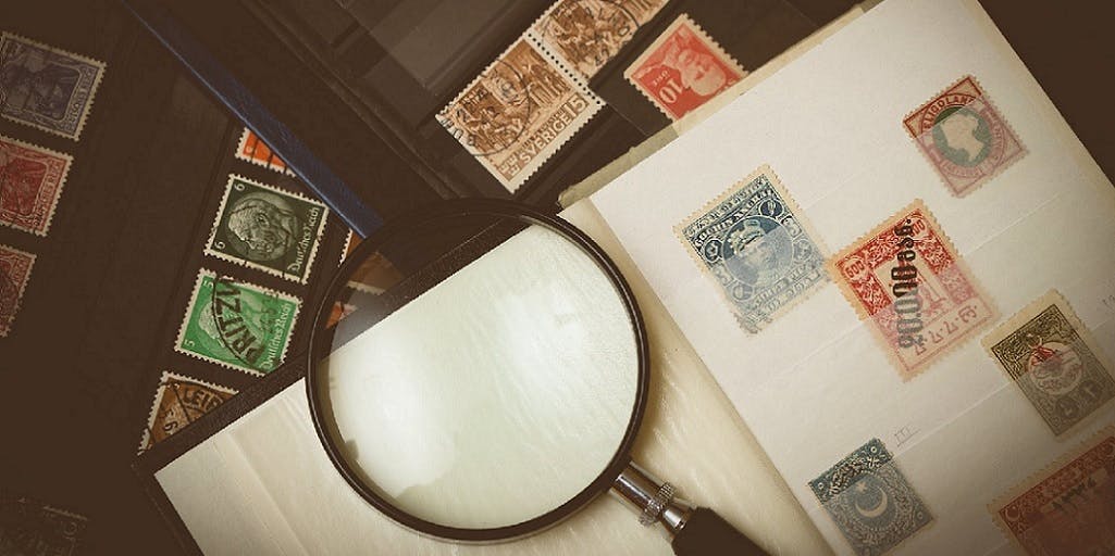Photo of stamp collector's collection and magnifying glass 