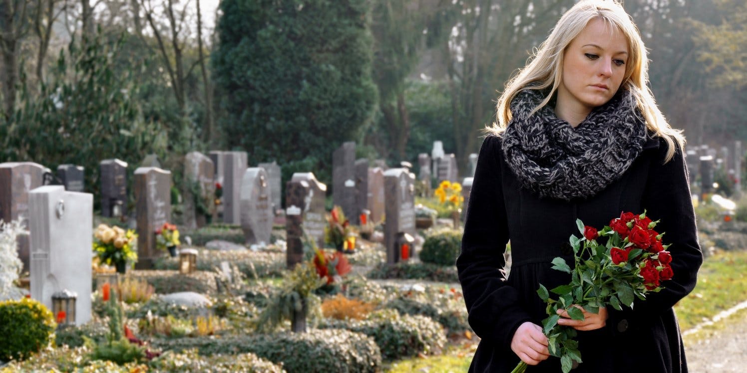 woman-holding-flowers-in-graveyard