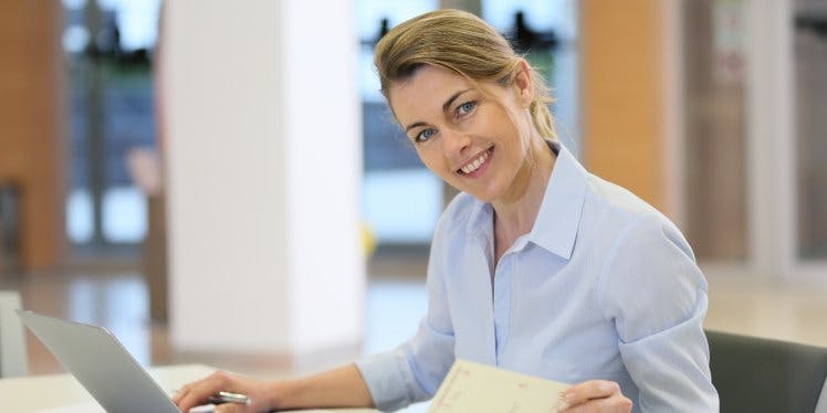 woman-at-desk-with-laptop-and-paperwork