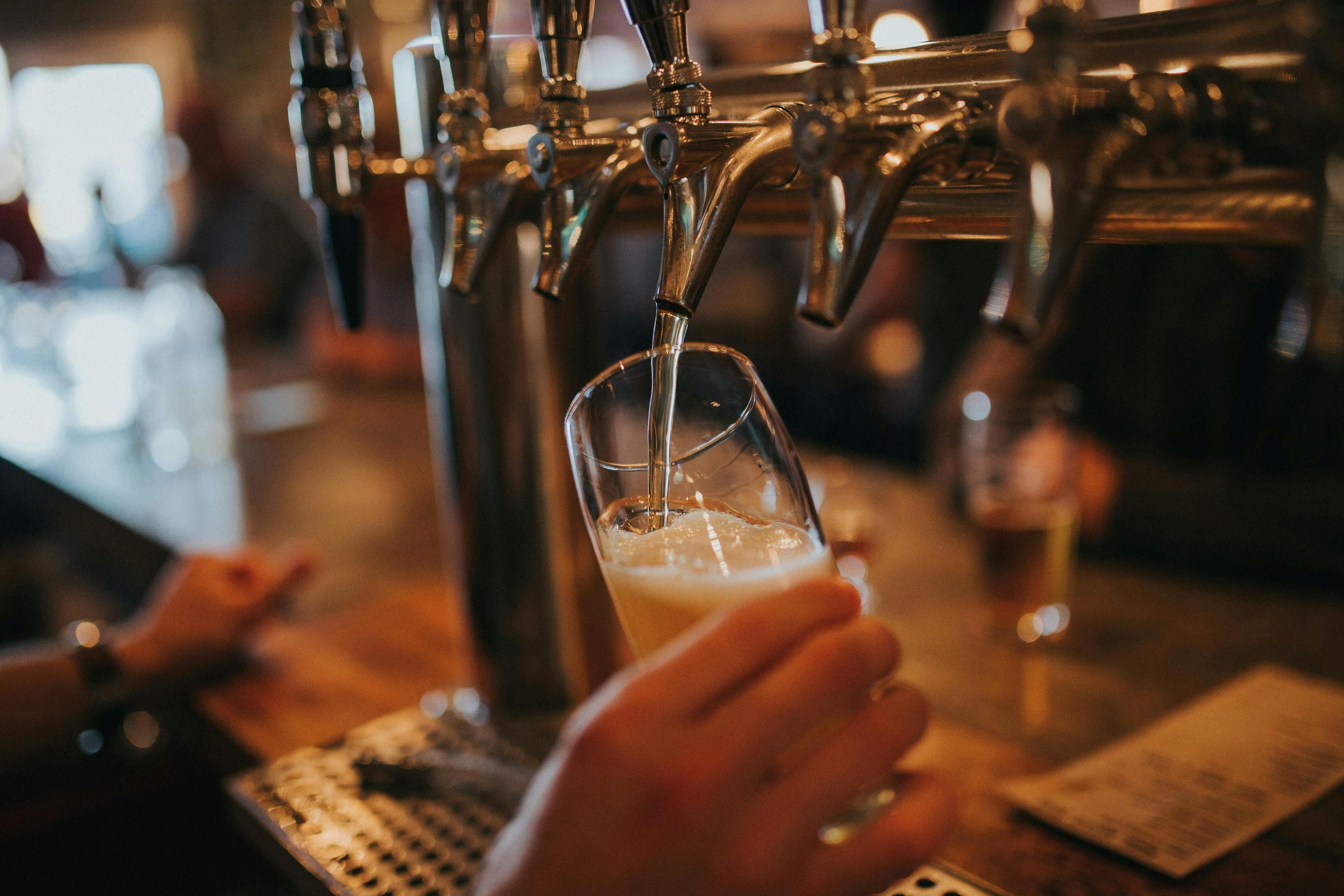Photograph of someone pouring a draught pint of beer.