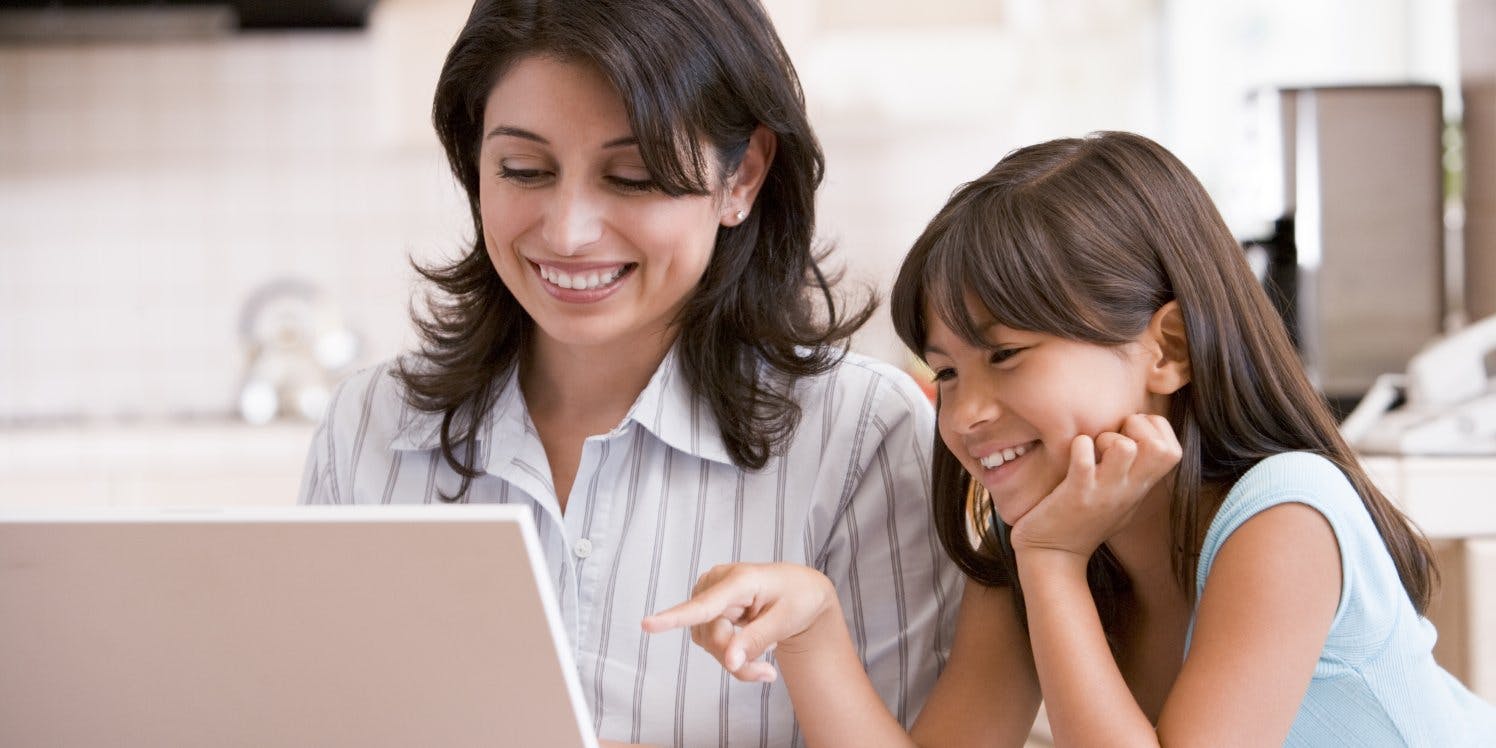 Woman and young girl looking at laptop