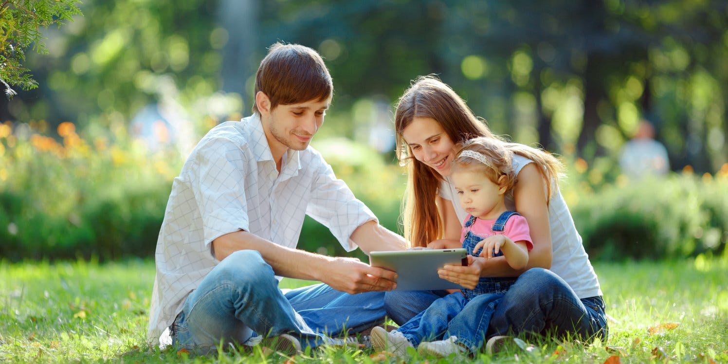 family-in-park-with-ipad-tablet