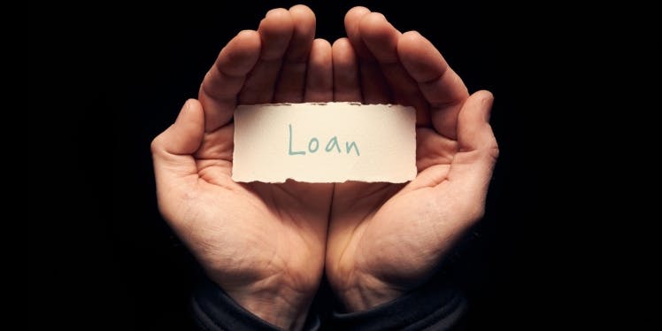 Open hands holding a label with the word loan 