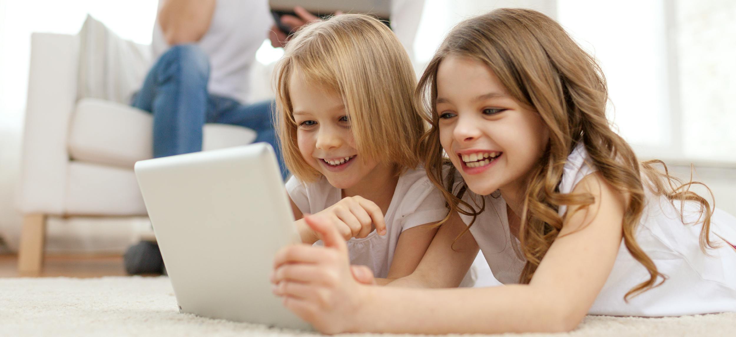 Image of 2 blond girls watching a screen