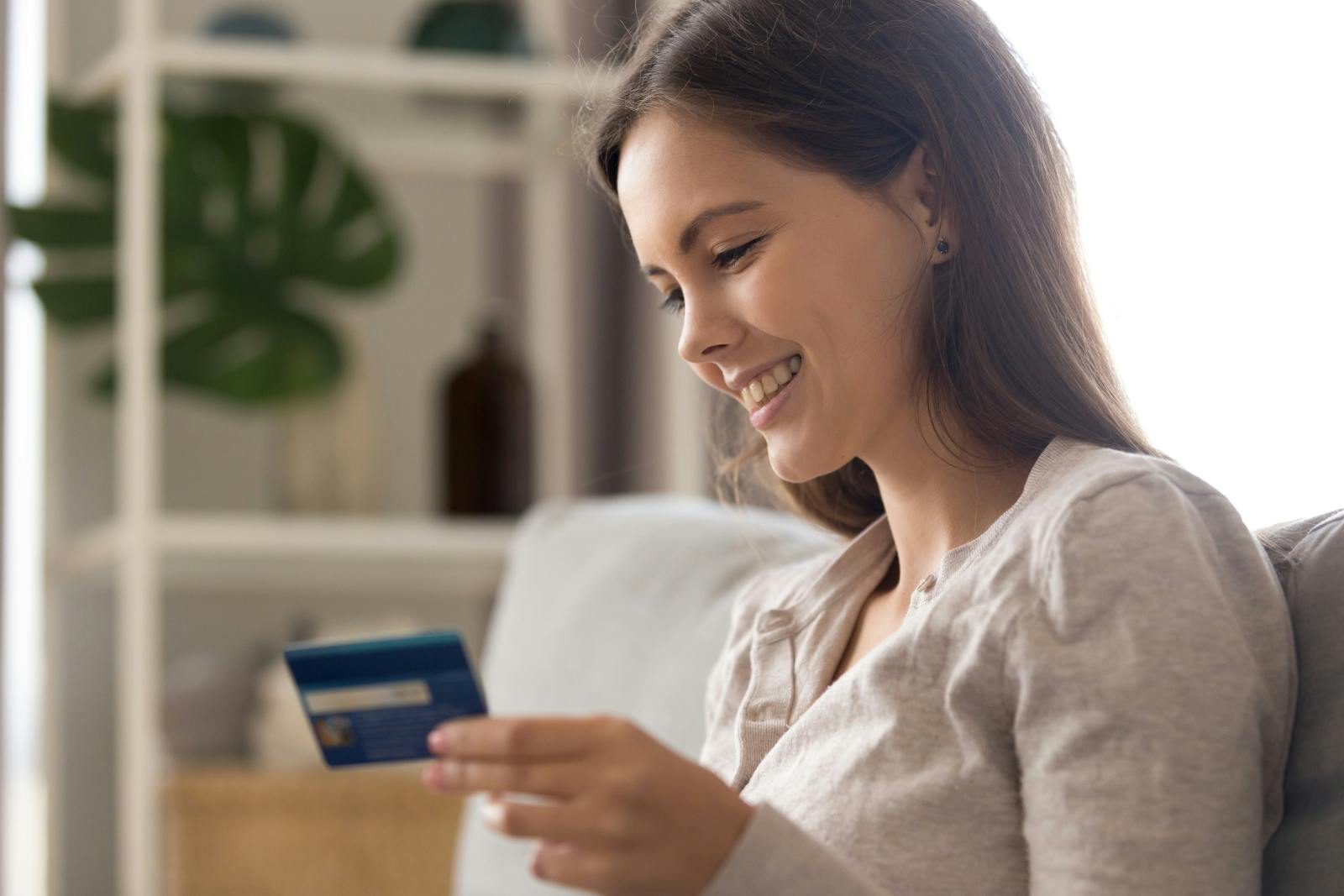 How to get fee free balance tranfers - woman smiling with credit card