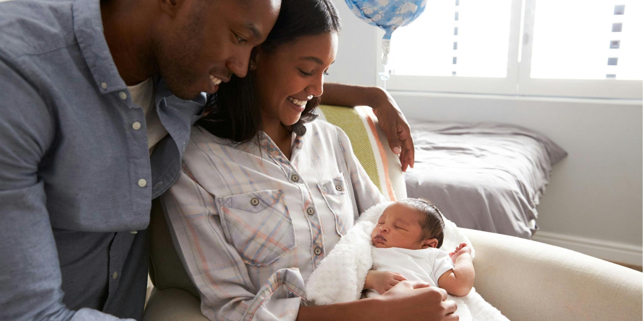 Happy and young black family with newborn baby.