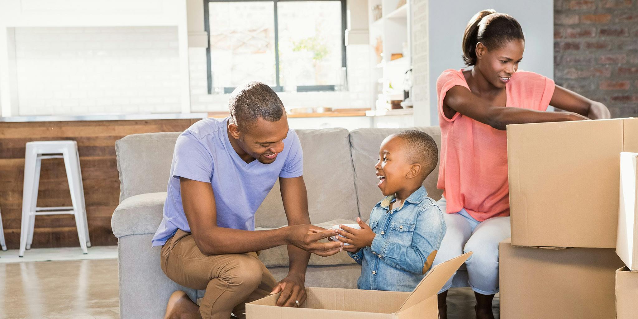African American family packing boxes to move house