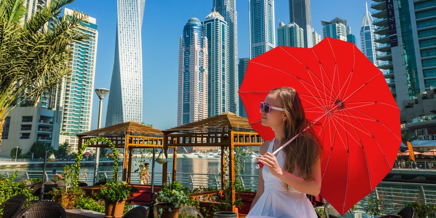 girl in city holding red umbrella