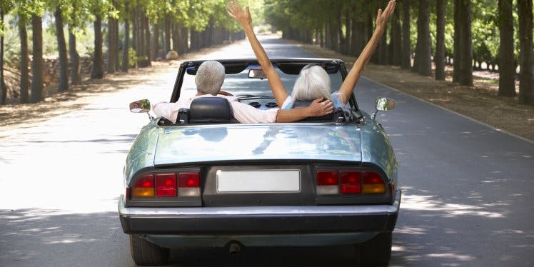 happy-retired-couple-driving-sports-car